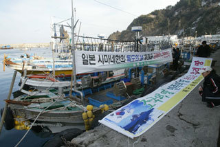 “일본은 야욕을 버려라”16일로 예정된 일본 시마네 현의 ‘다케시마의 날’ 제정을 하루 앞둔 15일 경북 울릉군 저동항에서 어민들이 어선에 일본의 독도 야욕을 규탄하는 현수막을 걸고 있다. 독도를 ‘자식 같은 섬’이라고 부르는 울릉도 주민들은 이날 일손이 잡히지 않는 듯 삼삼오오 모여 일본을 규탄하며 분통을 터뜨렸다. 울릉=안철민 기자