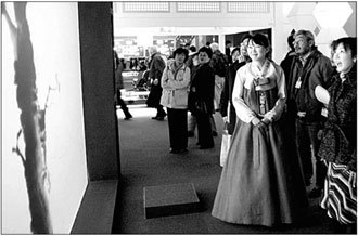 일본 아이치 현에서 25일 개막된 ‘2005 아이치 엑스포’에서 한국관을 둘러보고 있는 일본 관람객들이 수묵화 디스플레이를 쳐다보고 있다. 이 디스플레이는 관람객의 몸짓에 따라 수묵화가 그려지게 돼 있다. 사진 제공 KOTRA