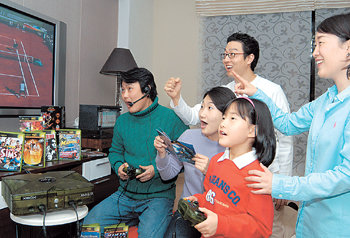 피트 샘프라스 등 유명 선수들이 플레이어로 등장하는 엑스박스의 테니스 게임 ‘탑스핀’을 가족이 함께 즐기고 있다.