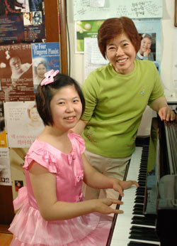 휴먼 다큐멘터리 ‘네 손가락의 피아니스트 희아’의 주인공 이희아(20) 씨와 그녀의 어머니 우갑선(50) 씨가 피아노 앞에서 환하게 웃고 있다. 이 씨는 “내 손은 아주 귀중한 보물”이라고 말했다. 사진 제공 MBC