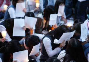 “얼굴 보이면 혼나요”7일 오후 서울 광화문 교보빌딩 앞에서 열린 ‘입시경쟁 교육에 희생된 학생들을 위한 촛불 추모제’에서 여고생들이 종이로 얼굴을 가린 채 앉아 있다. 추모제에 참석한 대다수의 학생들은 시위 내내 “신문에 사진이 나가면 부모님께 야단맞는다”며 이처럼 얼굴을 가리고 있었다.신원건 기자