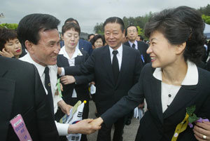 한나라당 박근혜 대표(오른쪽)가 18일 광주 국립5·18묘지에 들어가다 악수를 청하는 시민의 손을 잡고 있다. 광주=변영욱 기자