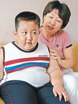 “꼭 나을거야”한도윤 군(왼쪽)의 어머니 박재은 씨가 지난달 31일 오후에 학교 수업을 마치고 집으로 돌아와 거실 소파에 앉아 있는 도윤이의 어깨를 다독거리고 있다. 권주훈  기자