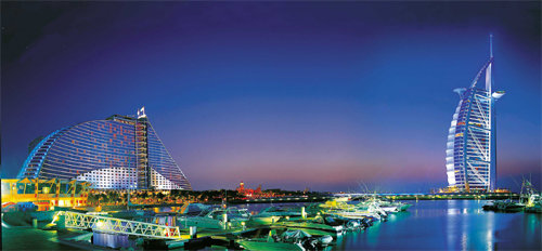 밀려오는 파도 모양의 주메이라 비치 호텔(왼쪽)과 바다에 뜬 요트의 바람안은 돛 모양의 버즈 알 아랍호텔이 있는 두바이의 주메이라 비치 밤풍경. 사진 제공 주메이라 인터내셔널