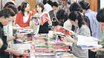 도쿄 ‘코리아 타운’으로 불리는 거리의 한 가게에서 일본인 손님들이 한류스타들이 소개된 한국 잡지에 푹 빠져있다. 사진 제공 아사히신문