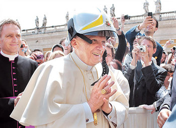 최근 성베드로 광장에서 한 신도가 장난삼아 소방관 헬멧을 씌워주자 교황 베네딕토 16세가 환하게 웃고 있다. 사진 제공 뉴욕타임스