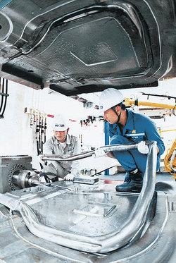 현대하이스코는 첨단 하이드로포밍 공법을 자동차 차체 제작에 적용해 경쟁력을 높이고 있다. 이 회사 울산공장에서 직원들이 하이드로포밍 공법으로 제작된 그랜드 카니발의 엔진 부분을 점검하고 있다. 사진 제공 현대하이스코