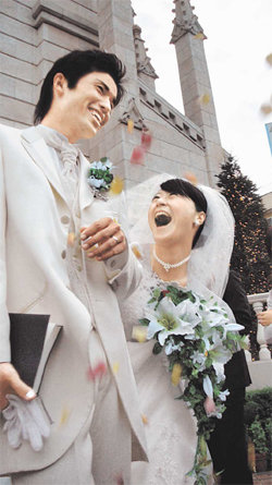 아쓰미 다카히로(왼쪽)와 미야가와 아쓰코 커플이 서양인 목사를 주례로 초빙해 결혼식을 마친 뒤 활짝 웃고 있다. 최근 일본에서는 ‘교회 결혼식’이 유행이다. 도쿄=박원재 특파원