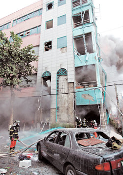 2일 오후 대구 수성구 수성동3가 시티월드 옥돌사우나에서 폭발음과 함께 화재가 발생했다. 건물이 화염에 휩싸이고 주변의 승용차가 크게 파손된 가운데 소방관들이 불길을 잡고 있다. 대구=연합뉴스