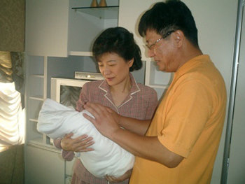 한나라당 박근혜 대표(왼쪽)가 12일 서울 강남구 청담동의 한 산부인과에서 동생지만 씨가 지켜보는 가운데 갓 태어난 조카를 안아보고 있다. 사진 제공 박근혜 대표실