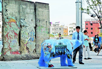 서울 속의 ‘베를린광장’통일을 염원하는 ‘베를린광장’이 서울 중구 청계천2가 삼일교 남단(한화빌딩 앞)에 조성돼 27일 개방된다. 광장은 ‘통일의 상징’인 독일 베를린장벽 일부와 베를린 시를 상징하는 곰 조형물, 의자와 100년 동안 베를린 시를 지켜온 가로등으로 꾸며졌다. 권주훈 기자