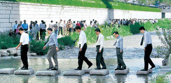 청계천 복원 이후 주변 직장인들의 점심시간 풍속도가 바뀌었다. 청계천 복원 이후 처음 맞는 평일인 4일 낮 직장인들은 김밥 샌드위치 등으로 간단히 점심을 때운 뒤 동료들과 함께 청계천을 따라 산책을 하거나 책을 읽는 등 한가로이 가을 햇살을 즐겼다. 넥타이를 맨 직장인들이 청계천 돌다리를 건너고 있다. 이종승  기자