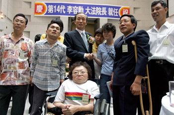 이용훈 대법원장(가운데)이 9월 26일 대법원에서 열린 제14대 대법원장 취임식을 마친 뒤 초청된 장애인들과 기념촬영을 하고 있다. 동아일보 자료 사진