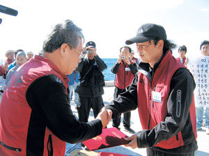 박영석 씨(오른쪽)가 10일 독도에서 동국대 고복현 부총장에게서 ‘동국 독도수호대’ 명예대장 임명장을 받고 있다. 독도=전 창  기자