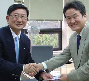 황성규 씨(오른쪽)가 지난달 25일 연세대 박영렬 대외협력처장에게 도서 구입비 500만 원을 전달하고 있다. 연합뉴스