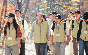 김승연 한화그룹 회장(가운데)이 3일 ‘한화가족을 위한 사랑의 행진’에 참가해 신입사원들과 함께 얘기를 나누며 걷고 있다. 그는 1박 2일간 100명의 신입사원과 함께 47km를 걸었다. 사진 제공 한화그룹