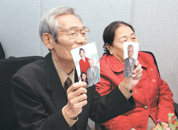 “사진 속 형님 만나고 싶었습니다”24일 서울 중구 남산동 대한적십자사에서 열린 남북이산가족 화상 상봉 행사에서 남측의 이영렬 씨(왼쪽)가 북측의 형님 가족 사진을 들고 모니터를 보며 대화를 나누고 있다. 김미옥 기자