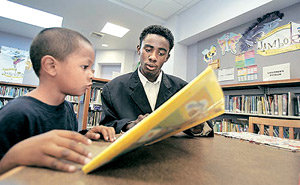에릭 존슨 군(오른쪽)에게 도서관은 인종 간 갈등이 없는 ‘중립 지역’이다. 26일 존슨 군이 미국 로스앤젤레스의 애스컷 도서관에서 다섯 살짜리 앤드루 헤르난데스가 책 읽는 것을 도와주고 있다. 사진 제공 LA타임스