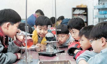 겨울방학 캠프를 준비하면서 부모와 자녀가 함께 계획을 잘 짜면 효과를 배가할 수 있다. 한 캠프에 참가한 어린이들이 알코올램프로 플라스크 속 액체를 가열하는 실험을 지켜보고 있다. 동아일보 자료 사진