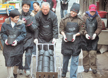 푸르메재단 이사장인 김성수 성공회대 총장(가운데)과 자원봉사자들이 6일 서울 영등포구 문래1동에 사는 독거노인에게 연탄을 전달하러 가고 있다. 원대연 기자
