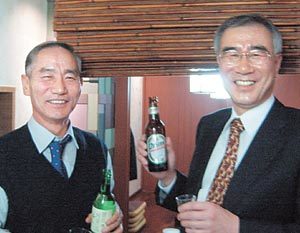 서로 술을 따라주며 환하게 웃고 있는 진로 하진홍 사장(왼쪽)과 하이트맥주 윤종웅 사장. 김상수 기자