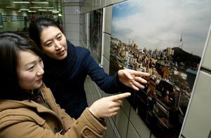 서울 지하철 3호선 무악재역 지하역사에서 8일 끝난 ‘일회용 카메라로 기록하는 뉴타운’ 전시회를 시민들이 보고 있다. 이 전시회는 9일까지 지하철 1호선 신길역, 5호선 방화역에서 열린다. 홍진환 기자