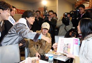 사학법 개정안의 무효화를 촉구하며 이틀째 장외투쟁을 벌이고 있는 한나라당 박근혜 대표가 14일 서울 강남고속버스터미널의 한 패스트푸드점에서 손님들에게 유인물을 나눠 준 뒤 악수를 청하고 있다. 전영한 기자