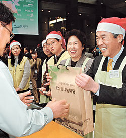 23일 포스코센터에서 열린 ‘포스코 나눔마당’ 행사에서 이구택 포스코 회장(오른쪽)이 부인 이정란 씨와 함께 임직원들이 기증한 물품을 판매하고 있다. 사진 제공 포스코