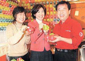 서울 송파구 잠실본동 삼겹살집 ‘계경목장’ 주인 양회성 씨(오른쪽)가 손님들과 함께 돼지저금통을 들고 환하게 웃고 있다. 이종승 기자 urisesang@donga.com