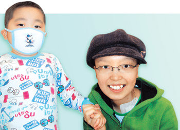 병상의 시인 김현영 양(오른쪽)이 지난해 11월 말 퇴원하기 직전 함께 생활해 온 한 어린 환자의 손을 꼭 잡고 있다. 홍수영 기자