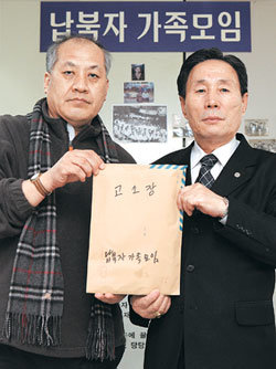 납북자 이재근 씨(오른쪽)와 납북자가족모임 최성용 대표가 8일 납북자가족모임 사무실에서 북한 정부 등에 보낼 고소장이 담긴 봉투를 들어 보이고 있다. 김재명 기자