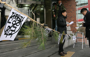 민주노총 관계자가 12일 알렉산더 버시바우 주한 미국대사의 방문을 막기 위해 서울 영등포구 대영빌딩 현관에 금줄을 쳐 놓았다. 금줄에 ‘전쟁광 미국’이라고 적힌 종이가 붙어 있다. 강병기 기자
