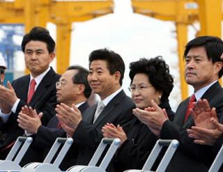 노무현대통령이 19일 부인 권양숙여사와 함께 부산 신항 개항식에 참석해 관계자와 함께 레버대를 작동시킨뒤 박수를 치고 있다.[청와대사진기자단]