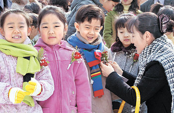 3월 자녀의 초등학교 입학을 앞둔 예비 학부모들은 가슴이 설레면서도 걱정이 많다. 선배 학부모들은 다른 학부모들과의 교류가 자녀의 학교생활을 이해하는 데 도움이 된다고 말한다. 지난해 한 초등학교 입학식에서 가슴에 꽃을 단 어린이들이 맑은 미소를 짓고 있다. 동아일보 자료 사진