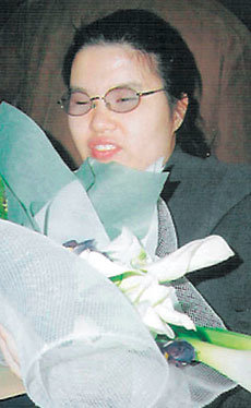 이화여대에 합격한 1급 시각장애인인 정아영 씨가 주변에서 건넨 축하 꽃다발을 들고 환하게 웃고 있다. 사진 제공 이화여대