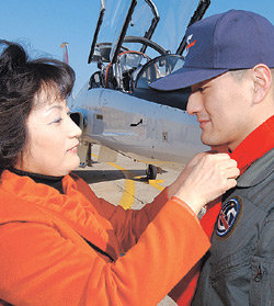 2일 공군 제16전투비행단에서 열린 고등비행교육 수료식에서 박인철 중위(오른쪽)에게 어머니가 ‘빨간 마후라’를 매어 주고 있다. 사진 제공 공군