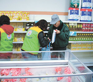 서울 양천구 신정동의 해누리 푸드마켓을 찾은 60대 노인이 자원봉사자의 도움으로 물품을 고르고 있다. 사진 제공 양천구 해누리 푸드마켓