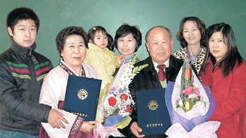 평생소원이던 중학교 졸업장을 받아 든 김기현 할아버지(오른쪽에서 세 번째)와 송정희 할머니(왼쪽에서 두 번째)가 16일 가족의 축하를 받고 있다. 사진 제공 남인천중고등학교