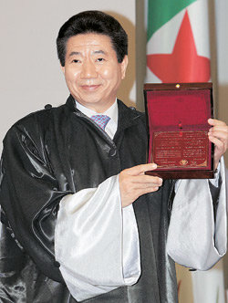 13일까지 아프리카를 순방한 노무현 대통령이 12일 오후(현지 시간) 알제리 수도 알제의 한 국제회의장에서 알제대로부터 정치국제관계학 명예박사 학위를 받았다. 노 대통령이 알제리의 민속 의상인 바르누스를 걸치고 박사학위 패를 들어 보이고 있다. 알제=석동률 기자