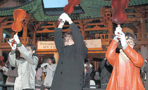 18일 저녁 서울 강남구 삼성동 봉은사에서 열린 백남준 씨의 49재 추모행사에서 일반 추모객 100명이 참여해 바이올린을 부수는 고인의 퍼포먼스 ‘바이올린을 위한 하나’를 재연했다. 연합뉴스