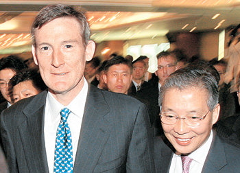 강정원 국민은행장(오른쪽)과 엘리스 쇼트 론스타 부회장이 23일 서울 영등포구 여의도 63빌딩에서 열린 외환은행 매각 관련 기자회견을 마치고 밝은 표정으로 회견장을 빠져나가고 있다. 홍진환 기자