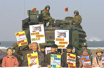 30일 충남 태안 만리포해수욕장에서 열린 한미합동군사훈련에서 시민단체 회원들이 훈련중단을 요구하며 장비이동을 막고 있다. 동아일보 자료사진