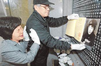 지난해 탈북을 시도하다 숨진 이헌우 중위의 딸 영희 씨(왼쪽)가 6일 서울 동작동 국립묘지에서 아버지의 위패를 확인한 뒤 울음을 터뜨리고 있다. 영희 씨는 아버지가 숨진 뒤 혼자 탈북해 지난해 말 한국에 도착했다. 고인의 사진을 들고 있는 사람은 납북자가족모임 최성용 대표. 원대연 기자