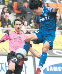 공중 점프 슛수원 삼성의 최성용(오른쪽)이 9일 수원월드컵경기장에서 열린 프로축구 전남 드래곤즈와의 경기에서 껑충 뛰어오르며 슛을 하고 있다. 경기 결과는 1-1 무승부. 수원=연합뉴스
