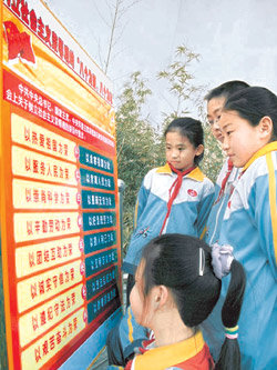 13일 산둥 성 칭다오개발구의 중학생들이 교내에 설치된, 바룽바츠 내용이 적힌 게시판을 바라보고 있다. 사진 제공 중국경제망