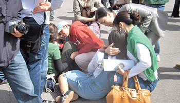 14일 한신대 만우관 앞 야외공연장 계단에 앉아있다가 승용차가 덮치자 급히 피한 신학과 학생들을 동료들이 살펴보고 있다. 1명이 현장에서 숨지고 14명이 중경상을 입었다. 사진 제공 오산소방서