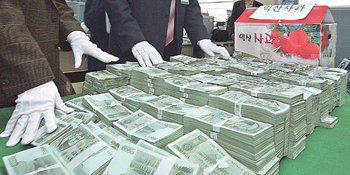 사과상자에 담아민주당 조재환 사무총장의 승용차 트렁크에서 발견된 사과상자에서 나온 뭉칫돈 4억 원을 서울경찰청 수사2계 수사관들이 확인하고 있다. 조 사무총장은 승용차에 돈이 들어 있는 줄 몰랐다고 주장했다. 원대연 기자