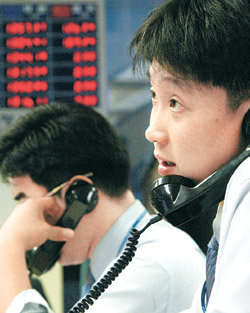 최근 미국 달러화에 대한 원화 환율이 하락 추세를 보이자 송금은 미루고 보유한 외화는 일찍 파는 등 ‘환테크’가 필요하다는 전문가의 충고가 늘고 있다. 서울 중구 외환은행 본점 딜링룸에서 한 외환 딜러가 추락하는 환율 시세표를 바라보고 있다. 동아일보 자료 사진