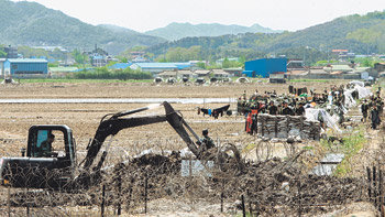 軍, 철조망 안쪽에 수로-둑 설치7일 군 공병대가 경기 평택시 주한미군기지 확장 예정지의 철조망 경계선 안쪽에 외부인들의 침입을 막기 위해 굴착기를 동원해 수로와 둑을 만들고 있다. 이날 주민과 군, 경찰 사이에 미묘한 긴장감이 감돌았다. 평택=박영대 기자