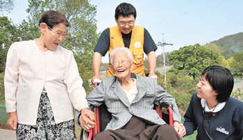 “이젠 가족같아요”서로에 대한 신뢰와 애정은 소록도 공동체를 수십 년 세월 동안 지탱해 온 원동력이다. 왼쪽부터 김복화 할머니, 김기현 할아버지, 용미정 간호사, 자원봉사자 한상철 씨(뒷줄)가 병원 앞뜰에서 따사로운 봄 햇살을 즐기고 있다. 안철민  기자